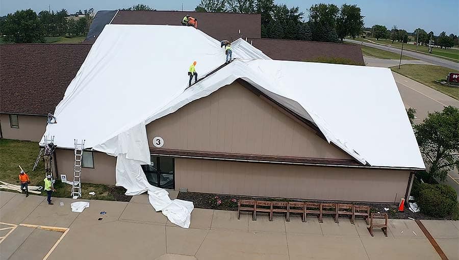 Roof Tarping Installation with white tarps.